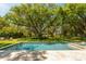 Beautiful pool with travertine tile surround, lush greenery, and ample space for entertaining or relaxation at 2802 Ion Ave, Sullivans Island, SC 29482
