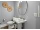 Bathroom with pedestal sink, decorative wall art, and vanity mirror, creating a stylish and functional space at 282 Great Lawn Dr, Summerville, SC 29486