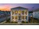 Charming two-story home with a double porch, white columns and blue shutters at dusk at 282 Great Lawn Dr, Summerville, SC 29486