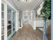 Inviting hallway with hardwood floors, blue doors, white trim, and decorative wreath, offering a warm and welcoming ambiance at 282 Great Lawn Dr, Summerville, SC 29486