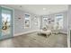 Bright living room features a modern couch, light wood floors and lots of natural light from several windows at 282 Great Lawn Dr, Summerville, SC 29486