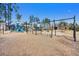Community playground featuring swings and slides with engineered wood fiber safety surface, backed by trees at 282 Great Lawn Dr, Summerville, SC 29486