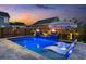 Backyard pool featuring a sun shelf, fountains, and two fire bowls surrounded by lush landscaping at 282 Great Lawn Dr, Summerville, SC 29486
