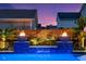 Close up of fire bowls and fountain feature in a backyard pool at dusk at 282 Great Lawn Dr, Summerville, SC 29486