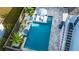 Aerial view of a modern pool with in-pool loungers, a striped umbrella, and tropical landscaping at 282 Great Lawn Dr, Summerville, SC 29486