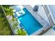 A luxurious pool with a sun umbrella, in-pool seating, palm trees, and accent fire bowls at 282 Great Lawn Dr, Summerville, SC 29486