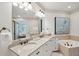 Primary bathroom showcasing double vanity sinks with granite countertops, bathtub, mirror, lighting, and neutral decor at 3 37Th Ave, Isle of Palms, SC 29451