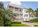 Beautiful three-story home with multiple balconies, a spiral staircase, palm trees, and a lush green lawn at 3 37Th Ave, Isle of Palms, SC 29451