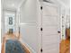 Bright hallway with hardwood floors, wainscoting, and a blue patterned rug leading to the bathroom at 3 37Th Ave, Isle of Palms, SC 29451