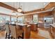 Expansive wooden kitchen with stainless appliances, marble countertops, eat-in island and designer lighting at 3 37Th Ave, Isle of Palms, SC 29451