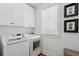 Functional laundry room with modern washer and dryer units, cabinet storage, and natural light at 3 37Th Ave, Isle of Palms, SC 29451