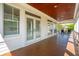 Back porch showcasing wood ceiling, wood floors, multiple sets of french doors, and neighborhood views at 3 37Th Ave, Isle of Palms, SC 29451