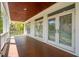 Exterior porch featuring a stained wood ceiling, wood floors, white columns, and multiple sets of french doors at 3 37Th Ave, Isle of Palms, SC 29451
