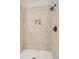 Shower featuring tiled walls, bronze fixtures, a shower niche, and neutral decor at 3 37Th Ave, Isle of Palms, SC 29451