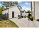 Backyard with a firepit, rocking chairs, black gate, white fence, white siding, and pavers at 308 Scholar Way, Summerville, SC 29486