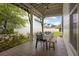 Covered porch with seating arrangement and view of a lush backyard and white picket fence at 308 Scholar Way, Summerville, SC 29486