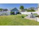 Backyard featuring lush grass, garden beds, and a quaint detached garage at 311 Amaryllis Ave, Summerville, SC 29483