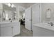 Bright bathroom with tile floors, a double vanity with white cabinets and doors that lead to an office at 311 Amaryllis Ave, Summerville, SC 29483