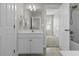 Well-lit bathroom with white cabinets, neutral tile floors, and a glimpse of the bedroom next door at 311 Amaryllis Ave, Summerville, SC 29483
