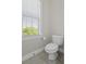 Clean, white bathroom with a toilet, window with blinds, and neutral wall paint creates a relaxing atmosphere at 311 Amaryllis Ave, Summerville, SC 29483