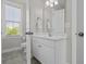 Bright bathroom with a white vanity and a door to the toilet and shower area at 311 Amaryllis Ave, Summerville, SC 29483
