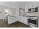 Open kitchen showcases stainless steel appliances, granite countertops, dining area and white cabinets at 311 Amaryllis Ave, Summerville, SC 29483