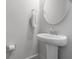 Stylish bathroom features a pedestal sink, round mirror, and classic fixtures at 3130 Sturbridge Rd, Mount Pleasant, SC 29466