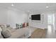 Bright living room features built-in shelving, a large TV, wood floors, and comfortable seating at 3130 Sturbridge Rd, Mount Pleasant, SC 29466