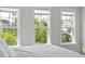 This main bedroom boasts large windows with views of mature trees and a sunny, refreshing vibe at 3130 Sturbridge Rd, Mount Pleasant, SC 29466