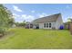 Expansive backyard featuring a large lawn, fenced perimeter, and a view of the house at 3154 Hugh Bennett Dr, Johns Island, SC 29455