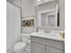 White bathroom features a white vanity, toilet, a mirror and shower with curtain at 3154 Hugh Bennett Dr, Johns Island, SC 29455