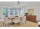 Dining room featuring a large window, modern chandelier, wood floors, and ample seating for entertaining at 3154 Hugh Bennett Dr, Johns Island, SC 29455