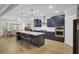 Bright, modern kitchen features an island with seating and stainless appliances with a dining area in the background at 3154 Hugh Bennett Dr, Johns Island, SC 29455