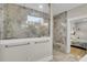 Walk-in shower with beautiful gray tile, glass door, window and bench at 3154 Hugh Bennett Dr, Johns Island, SC 29455