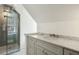 Bright bathroom featuring a marble countertop, gray cabinets, and a frameless glass walk-in shower at 32 Church St, Charleston, SC 29401