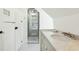 Bathroom featuring a marble countertop, gray cabinets, and a frameless glass walk-in shower at 32 Church St, Charleston, SC 29401