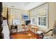 Bedroom nook featuring cheery yellow walls, warm wood floors, and stylish window coverings at 32 Church St, Charleston, SC 29401