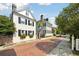 Charming homes lining a quaint brick street with mature trees and a sidewalk at 32 Church St, Charleston, SC 29401