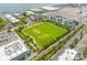 Aerial view showcasing a vibrant community with a soccer field, walking trails, and modern apartment buildings at 33 Calhoun St # 123, Charleston, SC 29401