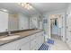 Well-lit bathroom featuring a double sink, granite countertop, and shower with patterned curtain at 33 Calhoun St # 123, Charleston, SC 29401