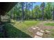 Large backyard with a stone path that leads to a luscious green yard, surrounded by tall trees at 3389 Prices Bridge Ln, Walterboro, SC 29488
