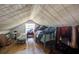 Attic bedroom featuring a low ceiling, a window, and a bed covered with clothes and clutter at 3389 Prices Bridge Ln, Walterboro, SC 29488