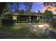 Rustic home with a cozy, inviting backyard setting with a fireplace and a covered porch with hammock at 3389 Prices Bridge Ln, Walterboro, SC 29488
