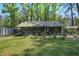 Exterior of a house with lush lawn, mature trees, an outdoor seating area, and a storage shed at 3389 Prices Bridge Ln, Walterboro, SC 29488