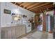 A charming kitchen with white cabinets, rustic wooden ceiling beams, and an adjacent dining area at 3389 Prices Bridge Ln, Walterboro, SC 29488