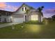 Charming single-Gathering home boasts a well-manicured lawn and features a mix of brick and siding at dusk at 349 Long Pier St, Summerville, SC 29486