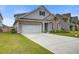 Inviting home showcasing a well-manicured lawn, concrete driveway, attached garage, and partial brick facade at 349 Long Pier St, Summerville, SC 29486