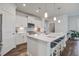 Open concept kitchen with white cabinetry, quartz countertops, stainless appliances, and seating at island at 349 Long Pier St, Summerville, SC 29486