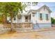 Charming exterior featuring white siding, light blue shutters and a brick wall around the raised front yard at 4 Addison St, Charleston, SC 29403