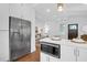 Gourmet kitchen featuring stainless steel refrigerator, microwave, custom white cabinetry, and hardwood floors at 4 Addison St, Charleston, SC 29403